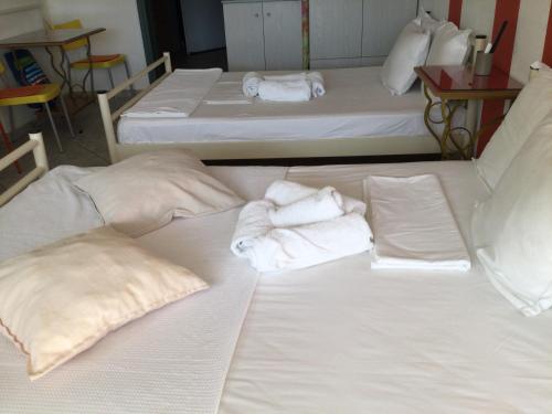 two beds in a room with towels on them at Igoumenitsa heart flats to let Mariasroom studios appart seaside-city Spyropoulos in Igoumenitsa