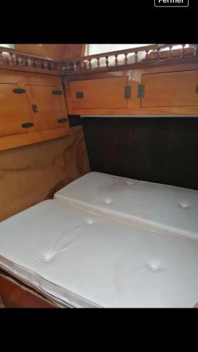 an empty bed in an rv with wooden cabinets at vacances de rêve sur la méditerranée in Empuriabrava