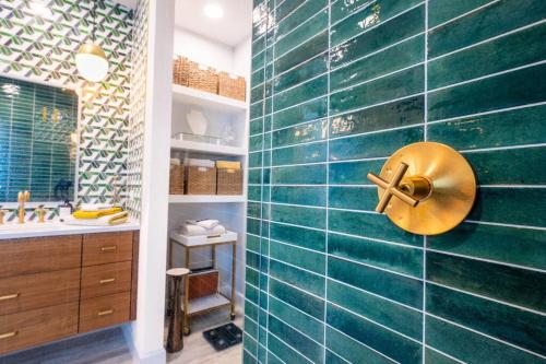 a bathroom with a sink and a shower with green tiles at Luxe Home-Designer BTHRM-Covered Deck-Weber Grill in San Antonio