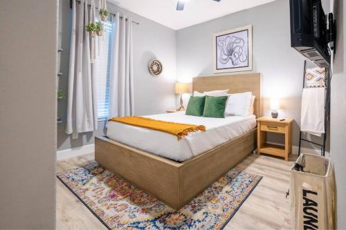 1 dormitorio con 1 cama con almohadas verdes en Luxe Home-Designer BTHRM-Covered Deck-Weber Grill en San Antonio