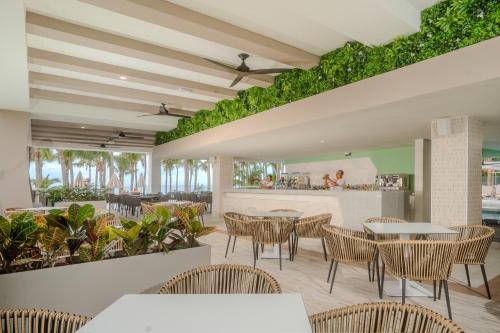 a restaurant with tables and chairs and a bar at Riu Palace Pacifico - All Inclusive - Adults Only in Nuevo Vallarta