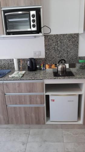 a kitchen with a counter top with a microwave at Depto Piacentini p/ 1 o 2 personas in Resistencia