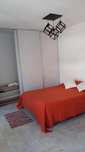 a bedroom with a red bed and a light at Depto Piacentini p/ 1 o 2 personas in Resistencia