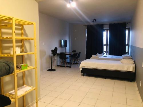 a bedroom with a bed and a table in a room at Excutive apartamentos in Joinville