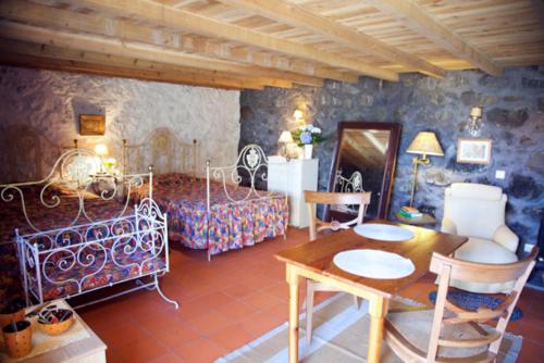 a bedroom with a bed and a table and chairs at Aldeia das Cagarras in Santo Amaro
