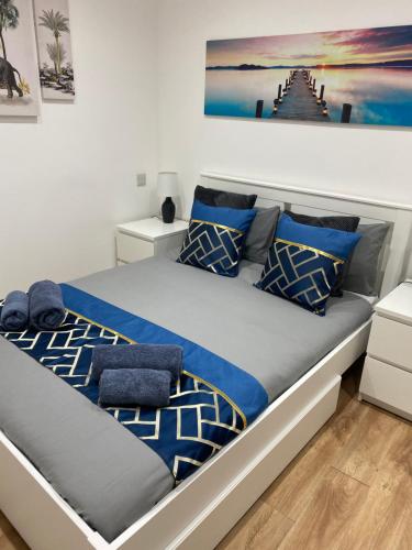 um quarto com uma cama com almofadas azuis em 51 Innes Street Apartment em Inverness