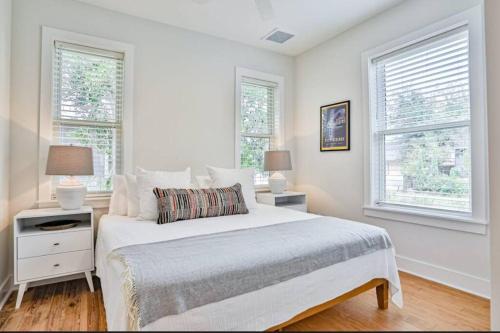 a white bedroom with a bed and two windows at Downtown Historic Charmer in Saint Augustine