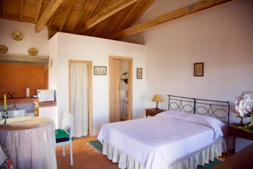 Santo Amaro的住宿－Aldeia das Cagarras，卧室配有一张白色大床和一张书桌