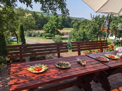 - une table de pique-nique en bois avec des bols de nourriture dans l'établissement Zemplén Cottage (breakfast&Tokaj wine tour), à Abaújalpár
