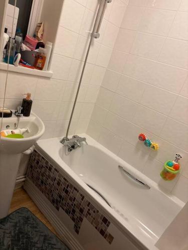 een badkamer met een bad en een wastafel bij Spacious flat in Tilehurst