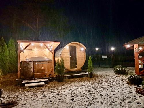 a small wooden cabin in the snow at night at Mazurski dom Brejdyny Sauna i Bania in Mrągowo