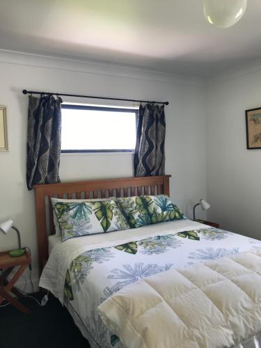 a bedroom with a large bed with a window at Woodbank Road Escape in Hanmer Springs