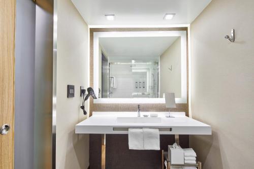 a bathroom with a sink and a mirror at AC Hotel by Marriott Orlando Lake Buena Vista in Orlando