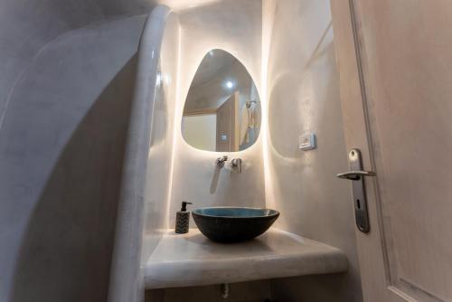 a bathroom with a bowl sink and a mirror at Blue Cave Oasis with Underground Jacuzzi in Megalokhori
