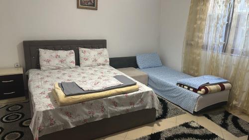 a small bedroom with a bed and a chair at Guri Guest House in Pogradec