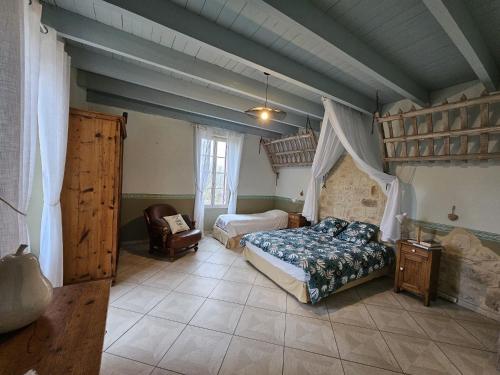 1 dormitorio con 1 cama y 1 silla en una habitación en Domaine Au Marchay, en Nojals-et-Clottes