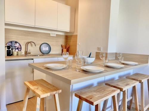 - une cuisine avec une table, des chaises et des verres à vin dans l'établissement PACA Properties 57A - Studio cosy, à Cannes