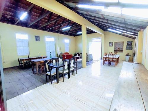 ein großes Zimmer mit Tischen und Stühlen und ein Zimmer mit Fenstern in der Unterkunft FutePoll in Teresa