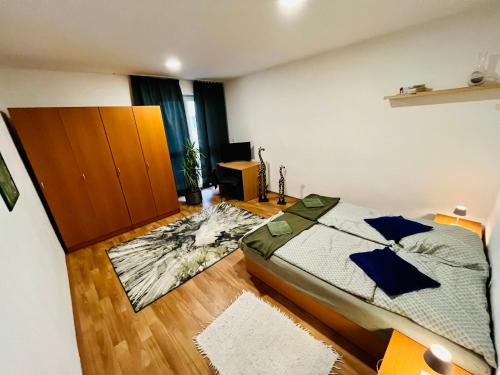 a bedroom with a bed and a wooden floor at JÓKAI Apartman in Komárno
