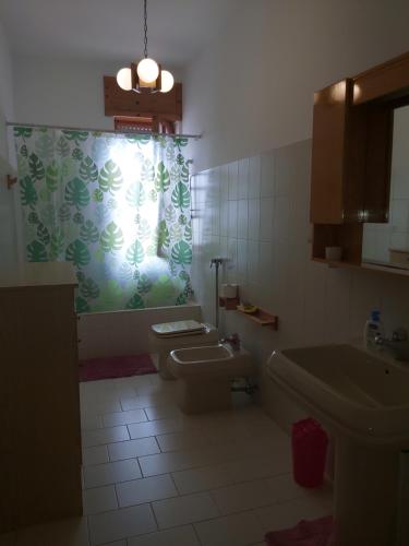 bagno con servizi igienici, lavandino e finestra di Villetta Alessia a Marina di Mancaversa