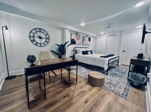 a bedroom with a bed and a desk and a clock at Urban Oasis in OTR Near Casino & Bell Event Centre! in Cincinnati