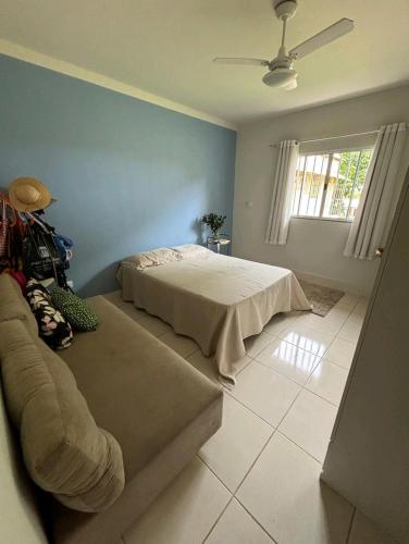 a bedroom with a bed and a couch at Casa do Renato in Anchieta