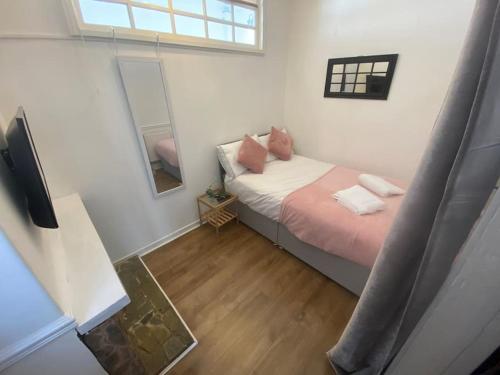 a small bedroom with a bed and a mirror at Warm family home close to City Centre (4bed) in Manchester