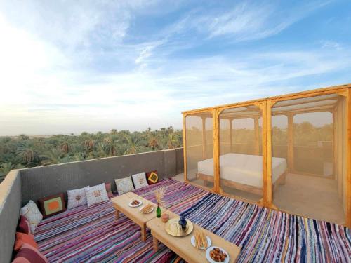 a room with a bed and a table on a roof at WAFLA in Siwa