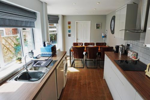 a kitchen with a sink and a table with chairs at Love Lane Villa in Lincoln