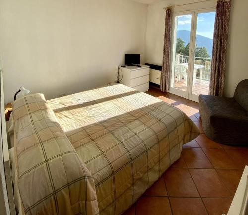 a bedroom with a bed and a chair and a window at Agriturismo L'Ulivo E Il Mare in Moneglia