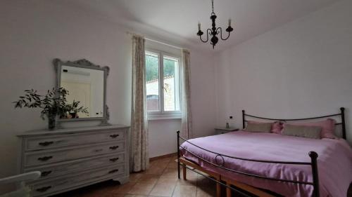 sypialnia z łóżkiem, komodą i lustrem w obiekcie Casa Ulivi e Mare w mieście Ventimiglia