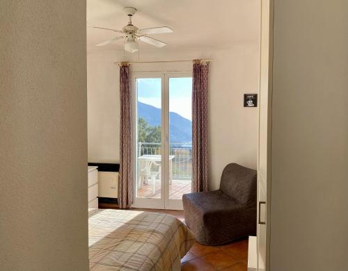 a bedroom with a bed and a chair and a window at Agriturismo L'Ulivo E Il Mare in Moneglia