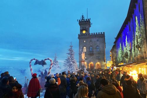 a crowd of people standing in front of a clock tower at La Famosa Dimora Ambasciatore in San Marino