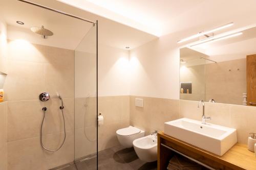 een badkamer met een douche, een toilet en een wastafel bij Hörmannhof in Bressanone