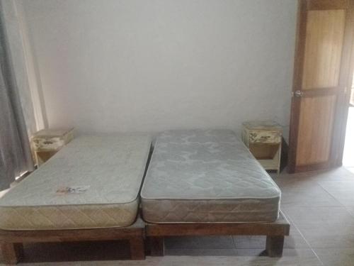 a bed in a room with two twin beds at Casa de campo con piscina en chincha in Ronceros Bajo