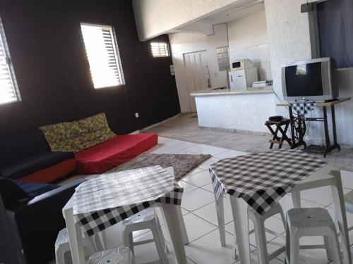 ein Wohnzimmer mit einem Sofa und einem Tisch mit Stühlen in der Unterkunft ParkFlat in Sorocaba