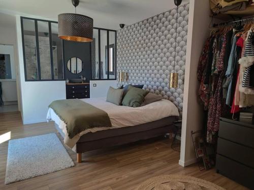 ein Schlafzimmer mit einem Bett und einer Fensterfront in der Unterkunft Villa contemporaine avec piscine in Magalas