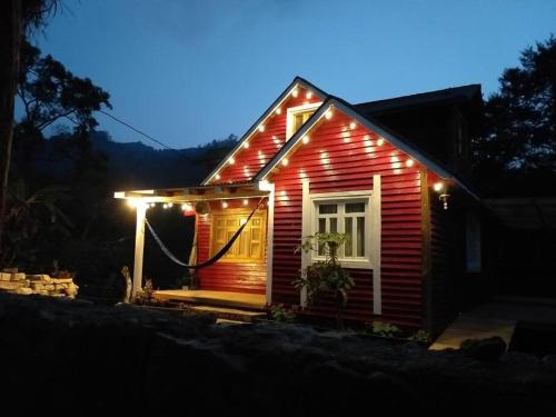 una pequeña casa roja con luces en el lateral. en The Shack, en San Martín