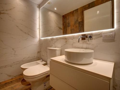 uma casa de banho branca com um WC e um lavatório em Palermo Soho Lofts at Russel em Buenos Aires