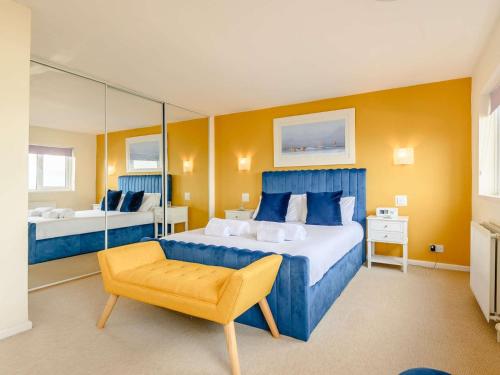 a bedroom with a blue bed and a yellow wall at 3 Bed in Brixham BX004 in Brixham