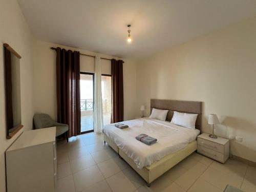 1 dormitorio con 1 cama grande y balcón en E13 Samarah Resort Apartment, en Sowayma
