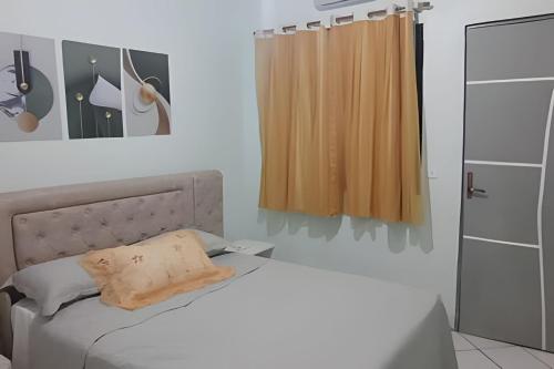 a bedroom with a white bed and a window at Pousada Souza Familiar in Porto Velho