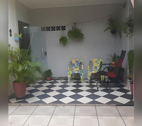 ein Zimmer mit 2 Stühlen und einem karierten Boden in der Unterkunft Pousada Souza Familiar in Porto Velho