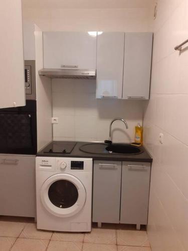 a kitchen with a washing machine and a sink at Appart entre Paris et Disney in Noisy-le-Grand