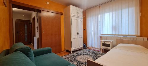 a bedroom with a couch and a bed and a window at Centar apartment in Belišće