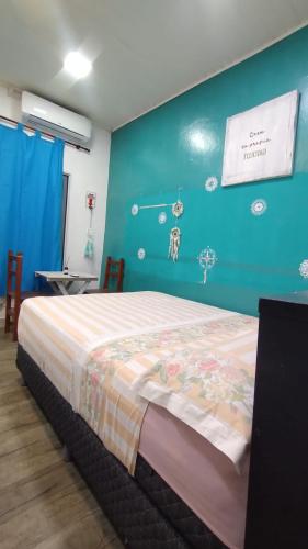 a bedroom with a bed and a blue wall at Creativa Home in Gualeguaychú