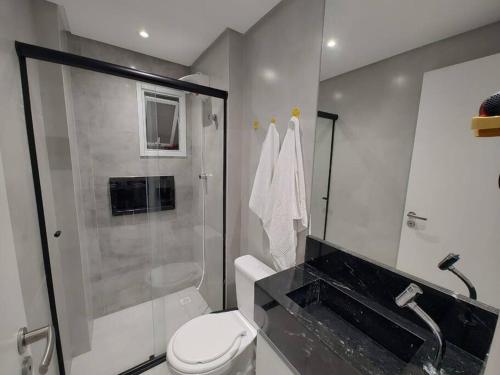 une salle de bain avec une douche, des toilettes et un lavabo dans l'établissement Apto com lazer completo, piscina, ar, mercadinho e pet friendly a 1 min da praia, à Praia Grande