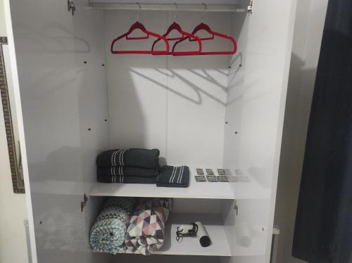 um armário branco com prateleiras vermelhas e sapatos em Apartamento inteiro próximo a Algar, Cargill, Aeroporto e UFU em Uberlândia