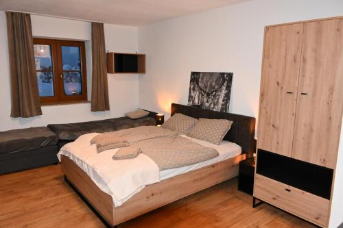 1 dormitorio con 1 cama y 1 sofá en Nicky, en Niederau