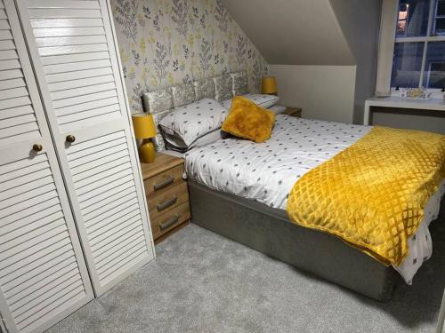 um quarto com uma cama com um cobertor amarelo em Harris Apartment em Montrose